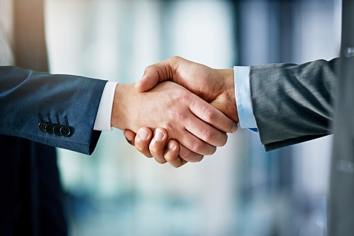 Closeup shot of two businessmen shaking hands in an office