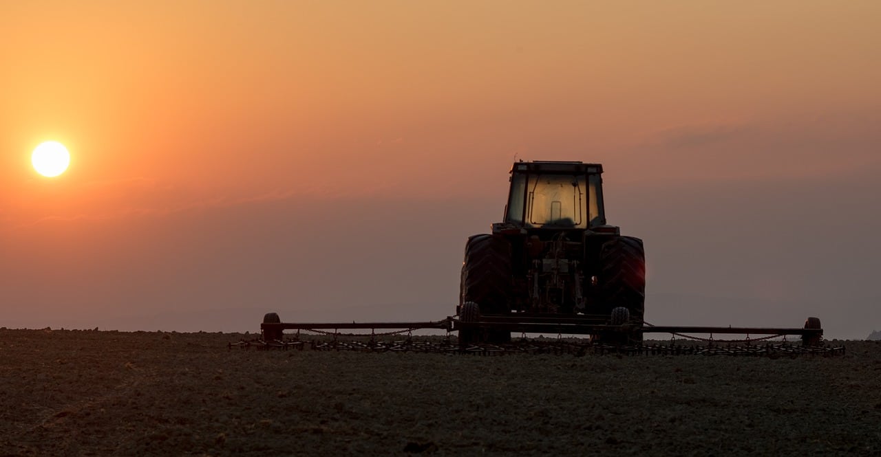 Tractor in field at sunset